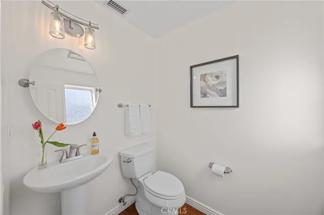 a bathroom with a toilet a sink and a mirror