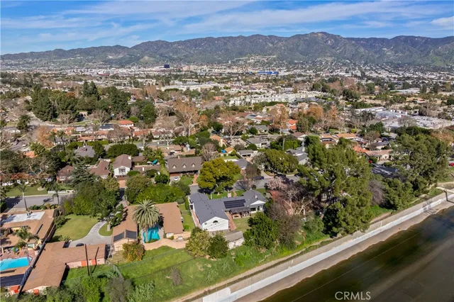 an aerial view of residential houses with outdoor space and trees