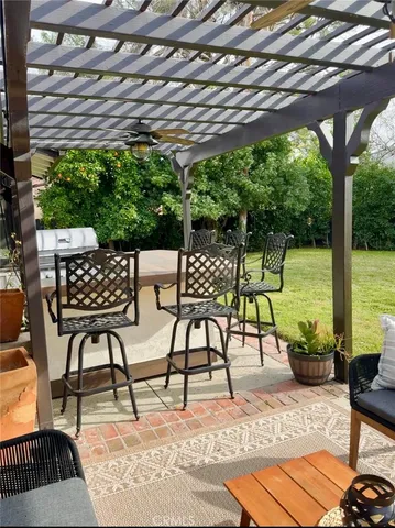 a view of a patio with table and chairs potted plants and large tree