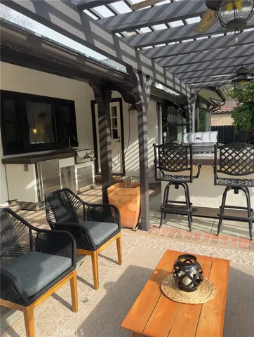 a living room with furniture a flat screen tv and kitchen view