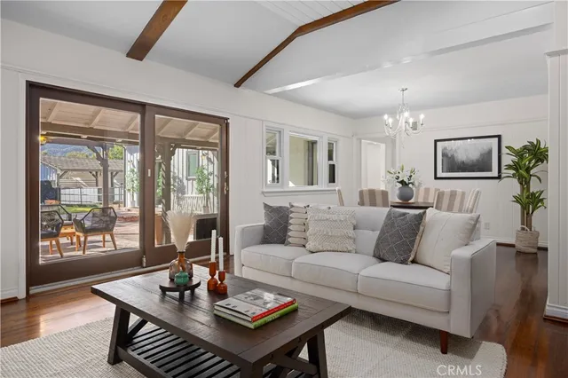 a living room with furniture a flat screen tv and a large window