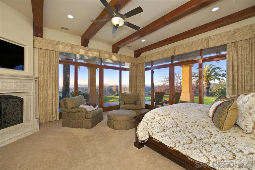 17087 Old Coach Road Poway, CA 92064 - Photo 20 of 25 a spacious bedroom with a large bed and a chandelier