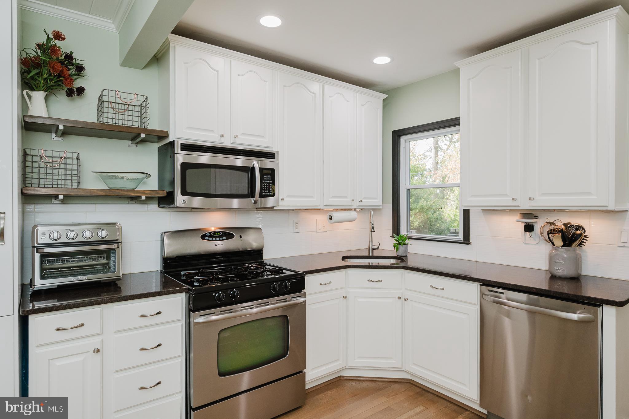 616 Sudbrook Road Baltimore, MD 21208 - Photo 18 of 58 a kitchen with granite countertop a sink cabinets stainless steel appliances and a window