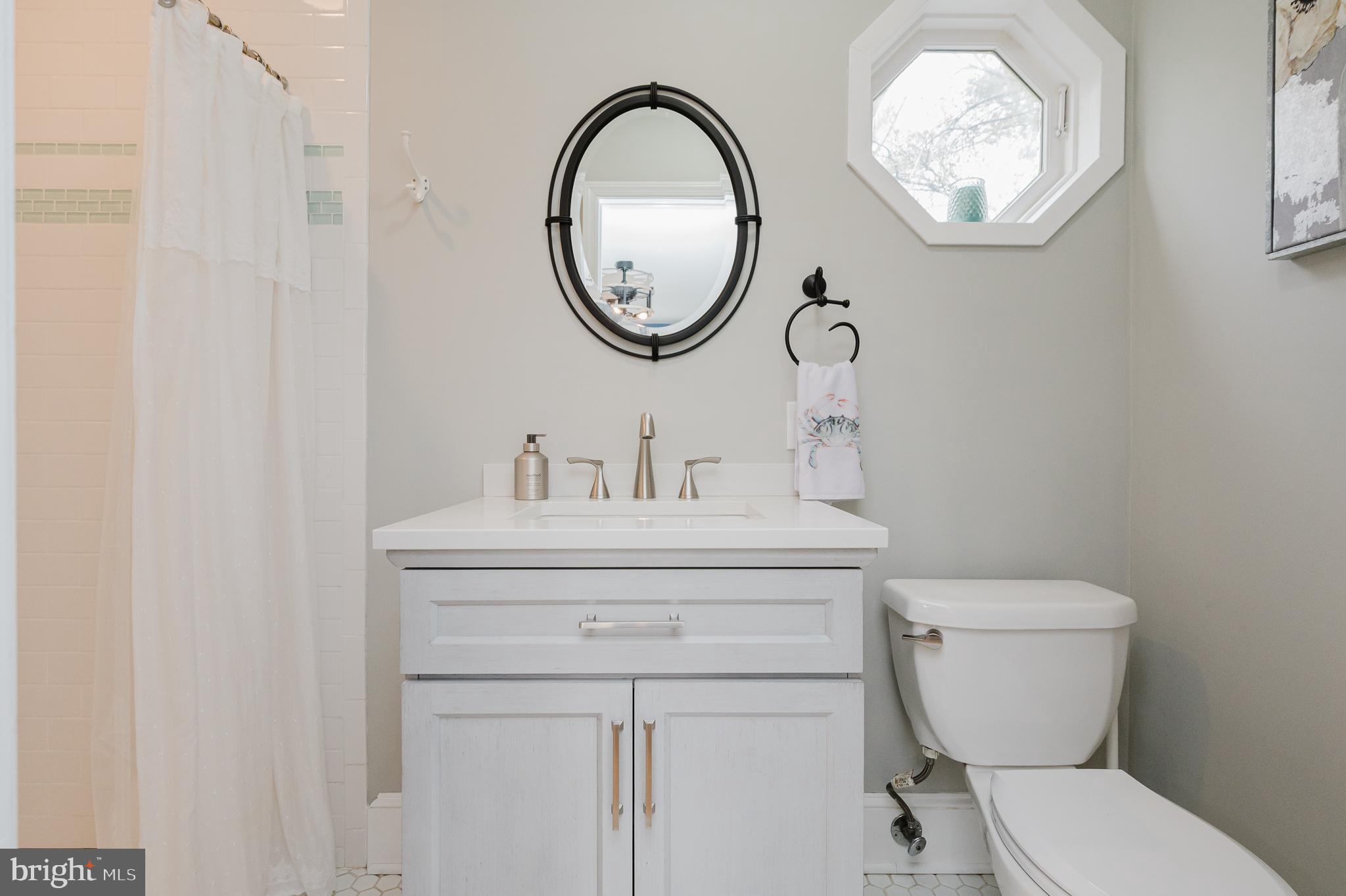 616 Sudbrook Road Baltimore, MD 21208 - Photo 29 of 58 a bathroom with a toilet a sink and a mirror