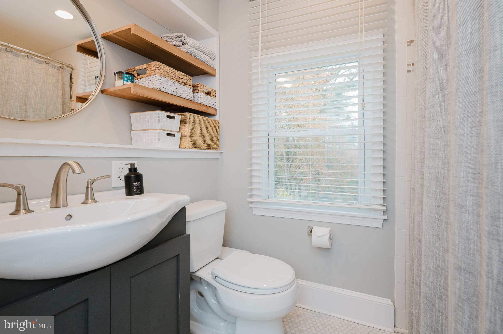 616 Sudbrook Road Baltimore, MD 21208 - Photo 41 of 58 a bathroom with a toilet a sink and a window