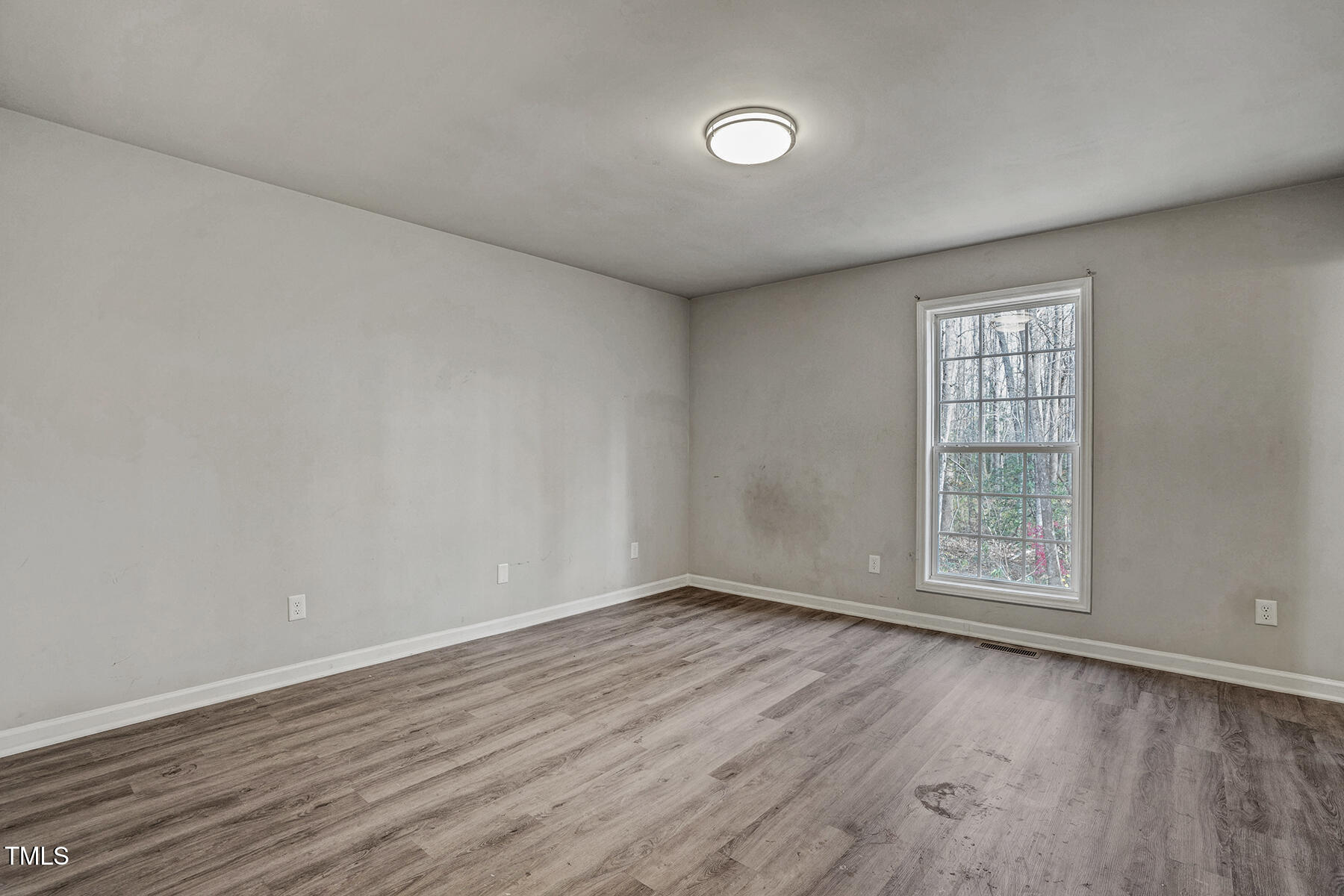 1506 Poplar Ridge Road Fuquay-Varina, NC 27526 - Photo 18 of 29 an empty room with wooden floor and windows