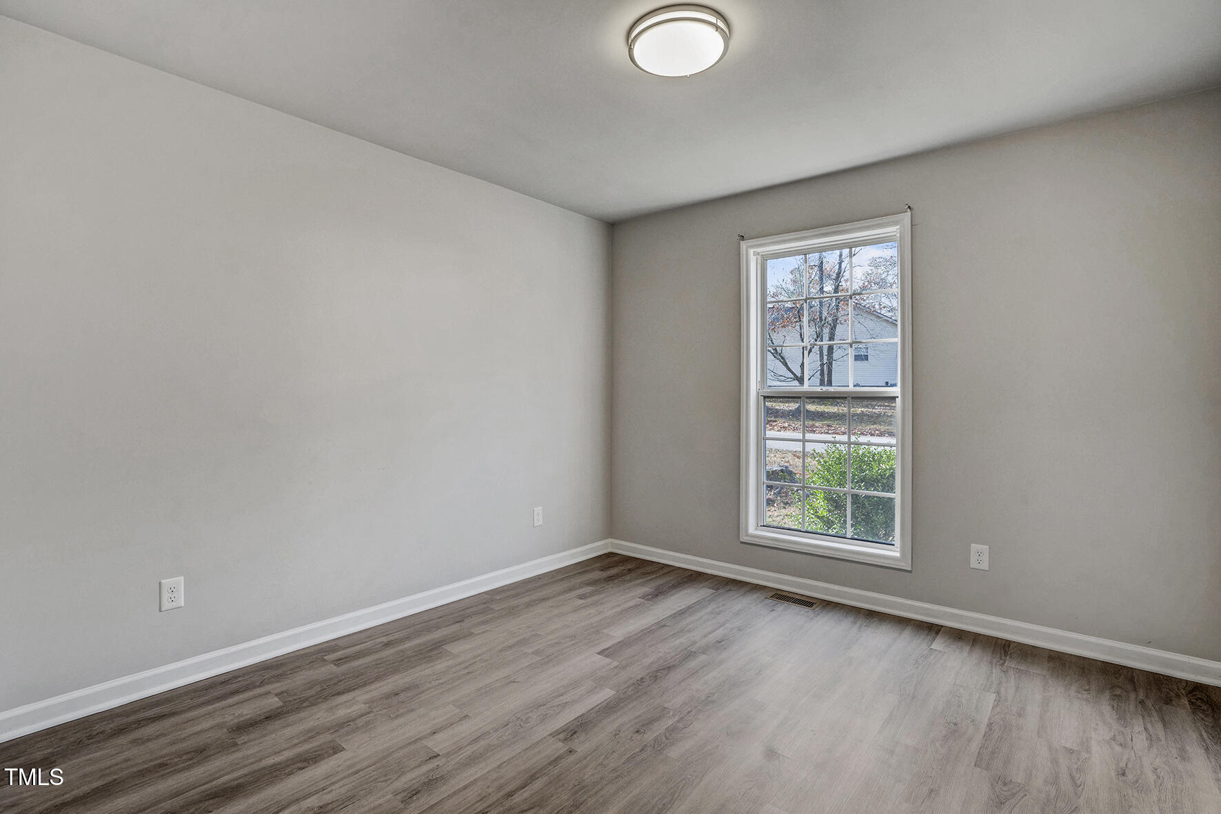 1506 Poplar Ridge Road Fuquay-Varina, NC 27526 - Photo 21 of 29 an empty room with wooden floor and windows