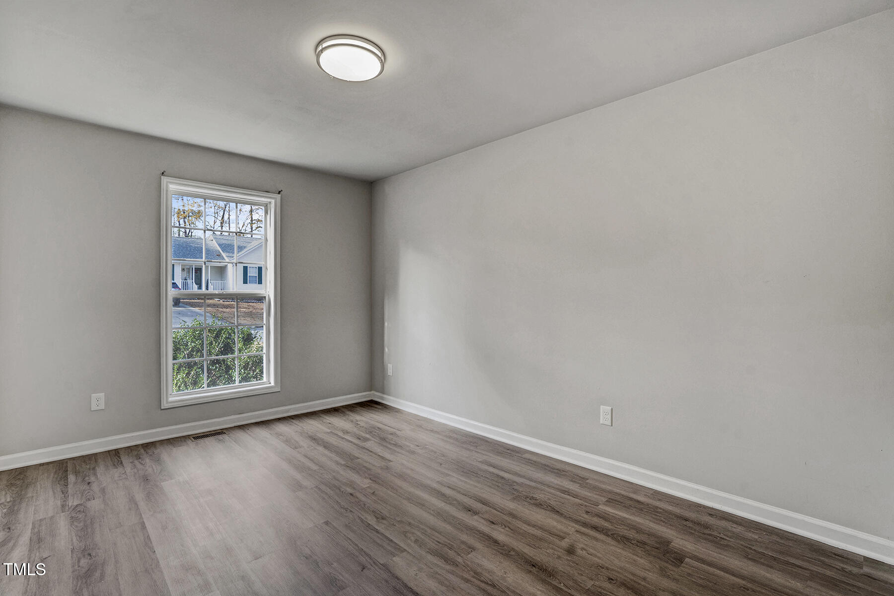 1506 Poplar Ridge Road Fuquay-Varina, NC 27526 - Photo 23 of 29 an empty room with wooden floor and windows