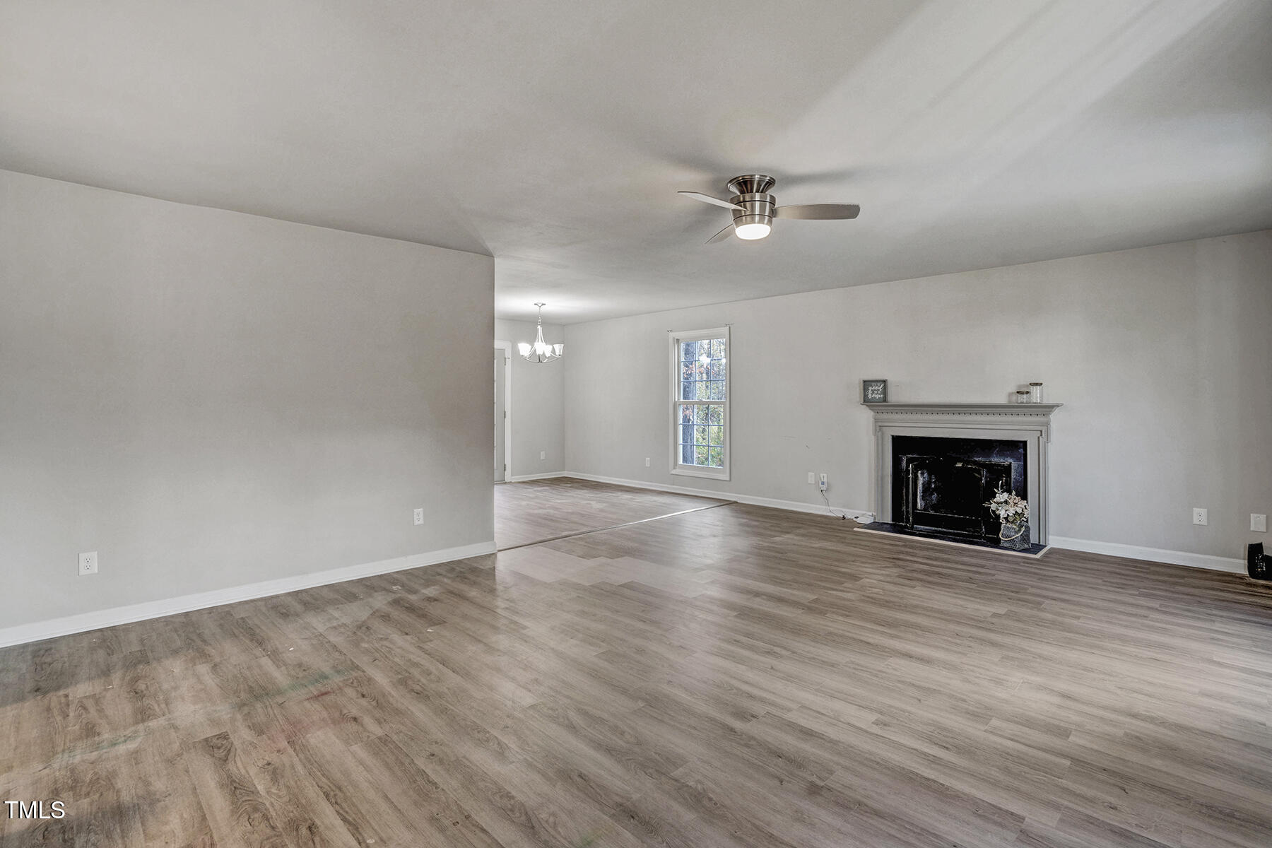 1506 Poplar Ridge Road Fuquay-Varina, NC 27526 - Photo 5 of 29 an empty room with wooden floor fireplace cabinet and windows
