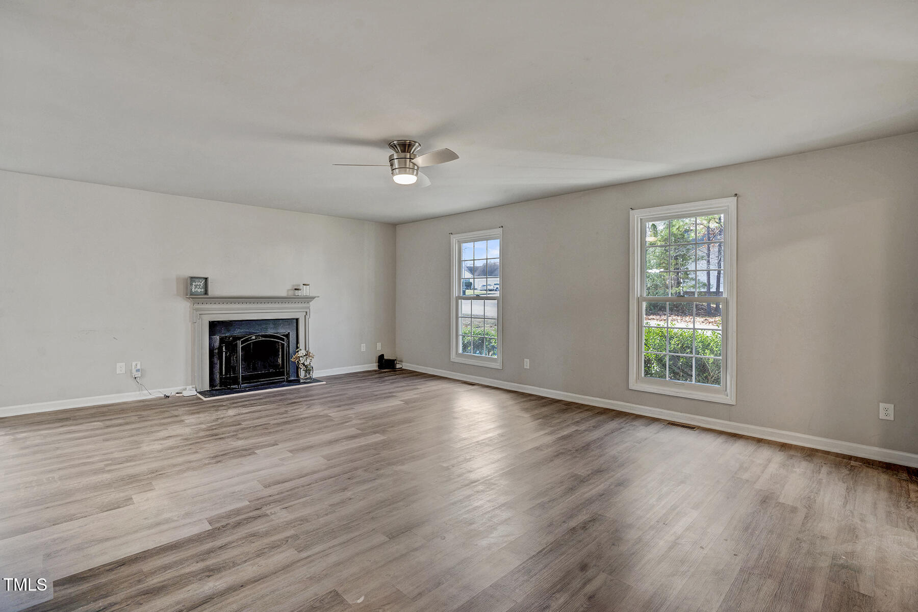 1506 Poplar Ridge Road Fuquay-Varina, NC 27526 - Photo 6 of 29 an empty room with windows a fireplace and wooden floor