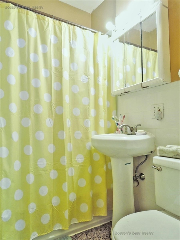 181 Allston, Unit 2 Boston, MA 02134 - Photo 11 of 18 a bathroom with a sink a toilet and shower curtain
