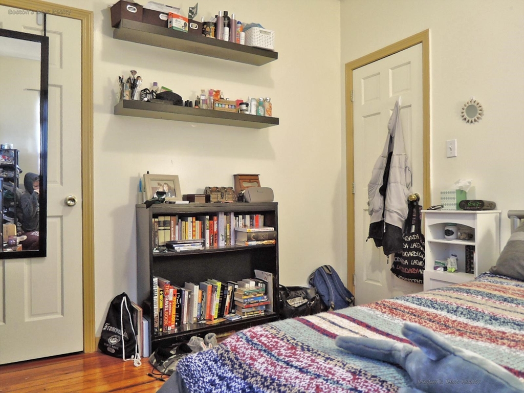 181 Allston, Unit 2 Boston, MA 02134 - Photo 15 of 18 a bedroom with furniture and a book shelf