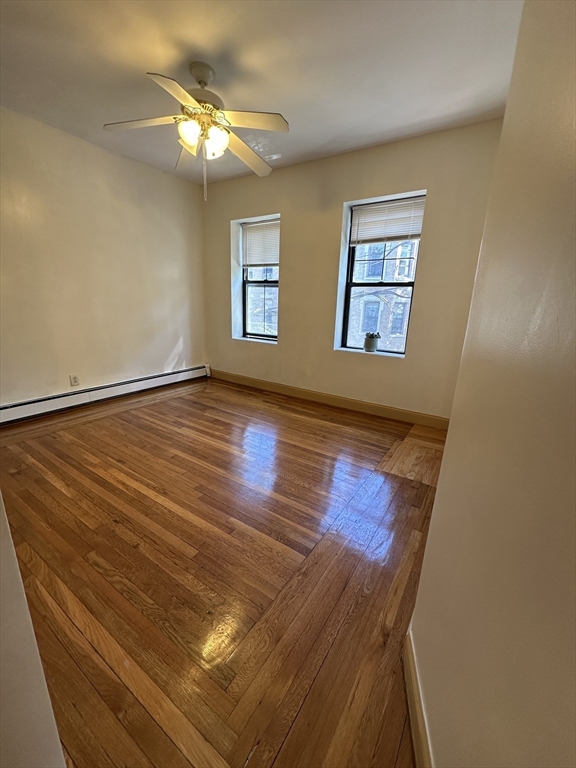 181 Allston, Unit 2 Boston, MA 02134 - Photo 2 of 18 a view of an empty room with wooden floor and a window