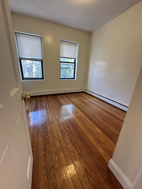 181 Allston, Unit 2 Boston, MA 02134 - Photo 3 of 18 a view of an empty room with wooden floor and a window