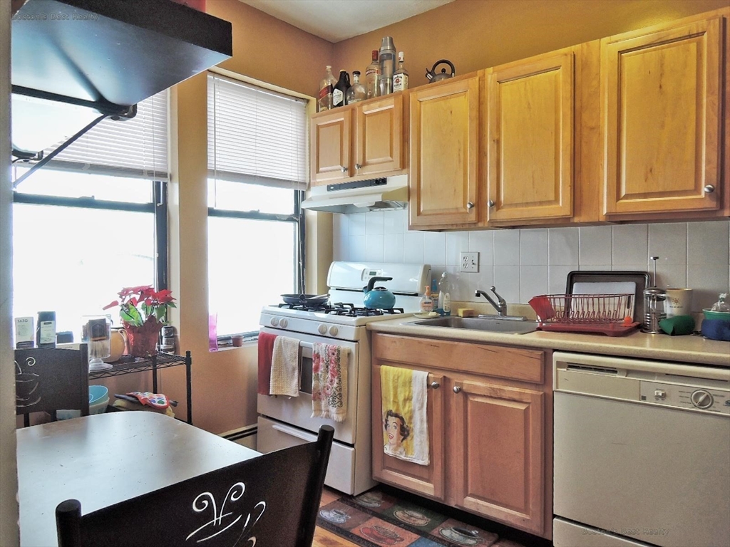 181 Allston, Unit 2 Boston, MA 02134 - Photo 7 of 18 a kitchen with stainless steel appliances granite countertop a sink dishwasher and cabinets with wooden floor