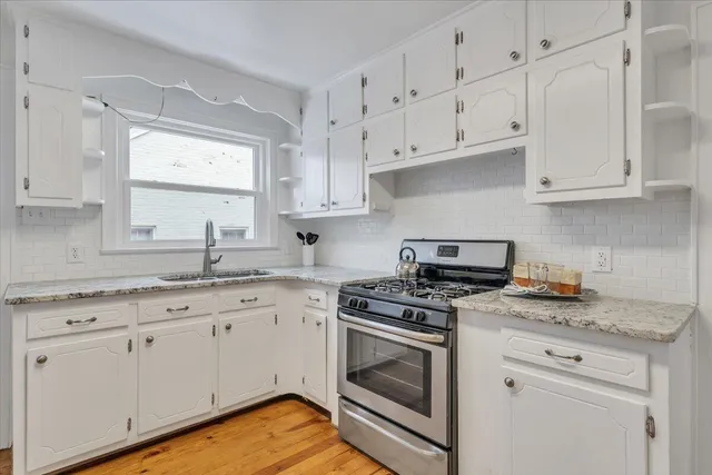 a kitchen with granite countertop a sink stove and refrigerator