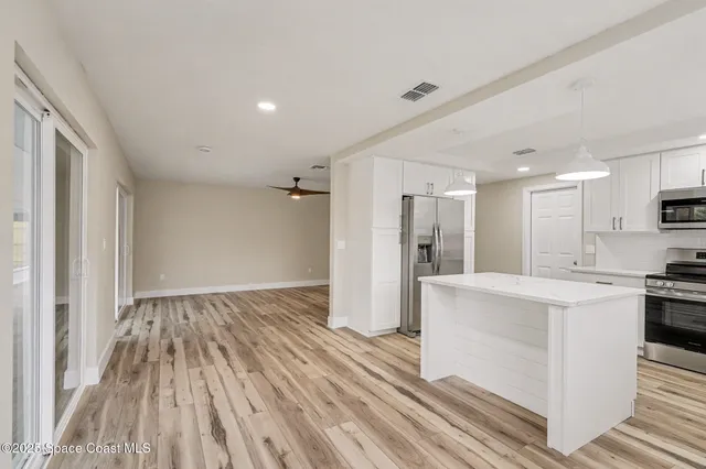 a view of kitchen with sink and refrigerator