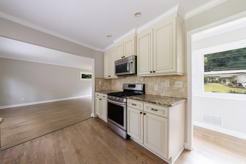 3838 Longview Drive Chamblee, GA 30341 - Photo 21 of 45 a kitchen with stainless steel appliances granite countertop a stove a sink and a microwave