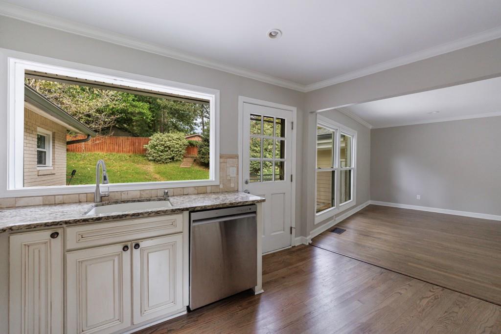 3838 Longview Drive Chamblee, GA 30341 - Photo 22 of 45 a kitchen with granite countertop a stove a sink and wooden floors