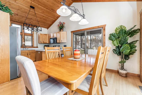a dining room with furniture a potted plant and wooden floor