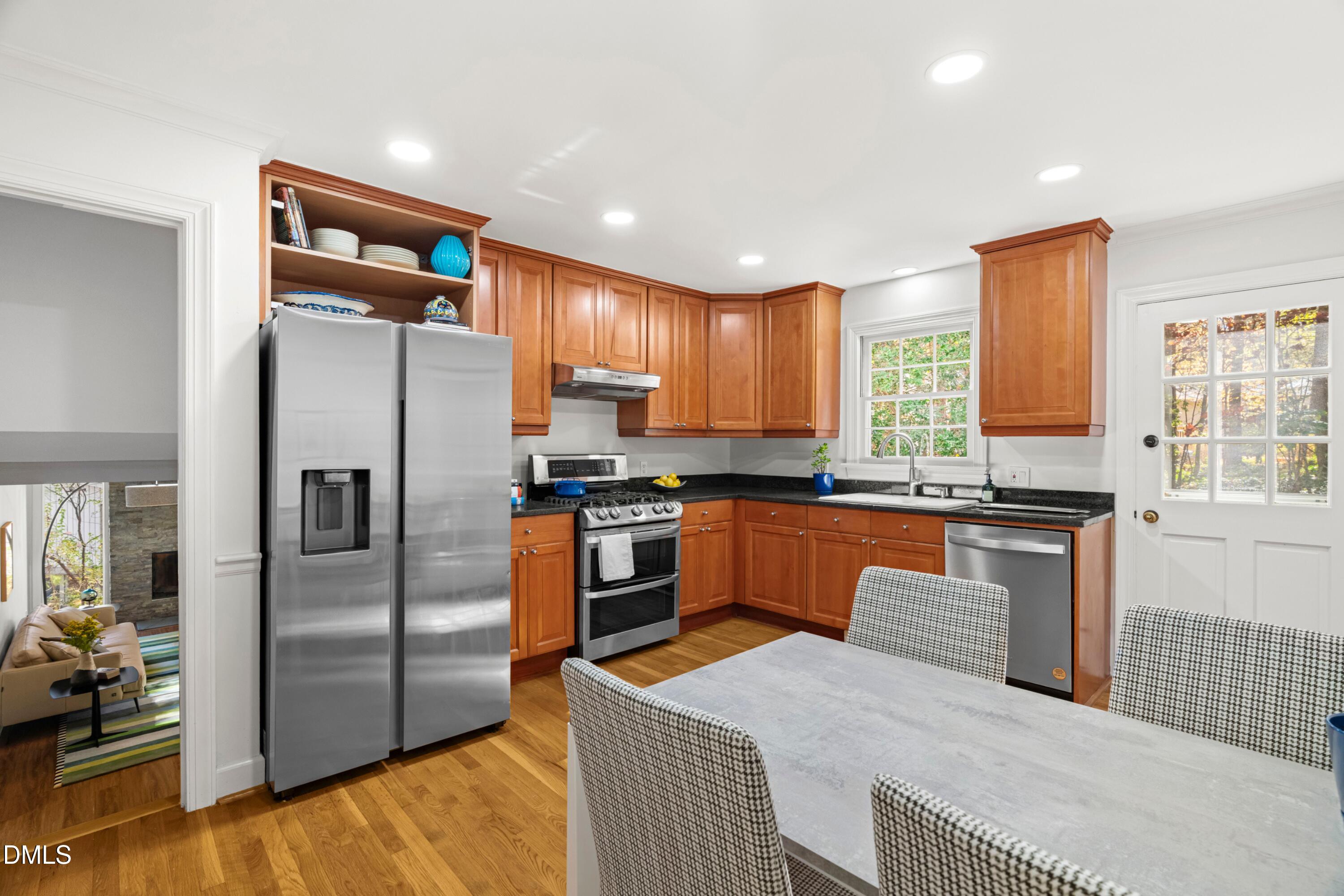 2105 Yorkgate Drive Raleigh, NC 27612 - Photo 13 of 42 a kitchen with stainless steel appliances granite countertop a refrigerator a stove and a sink with wooden floor