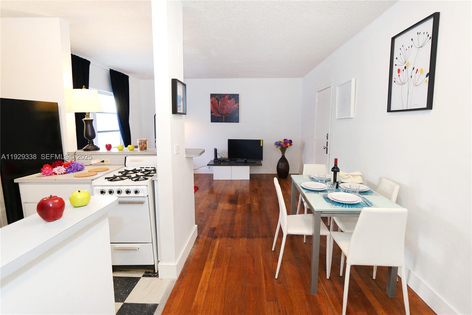 807 Alton Road Miami Beach, FL 33139 - Photo 5 of 7 a kitchen that has a table chairs and a refrigerator