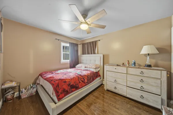 a bed room with a bed and a ceiling fan