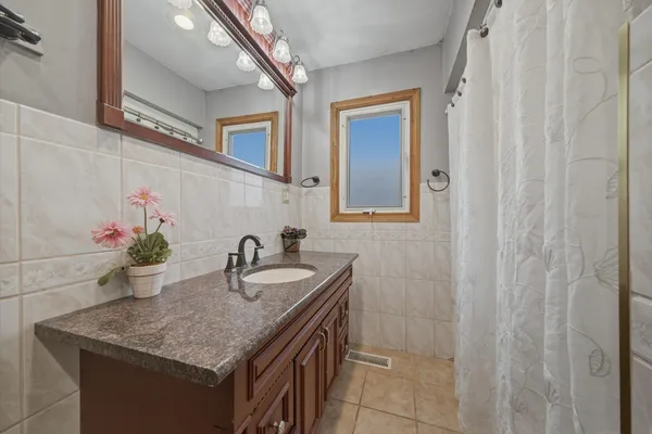 a bathroom with a granite countertop sink a mirror and vanity
