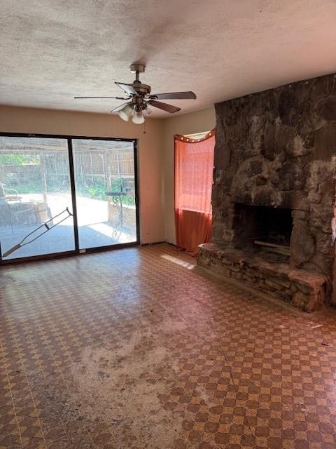 9800 North County Road Frisco, TX 75033 - Photo 5 of 14 Unfurnished living room featuring a textured ceiling, a fireplace, and ceiling fan