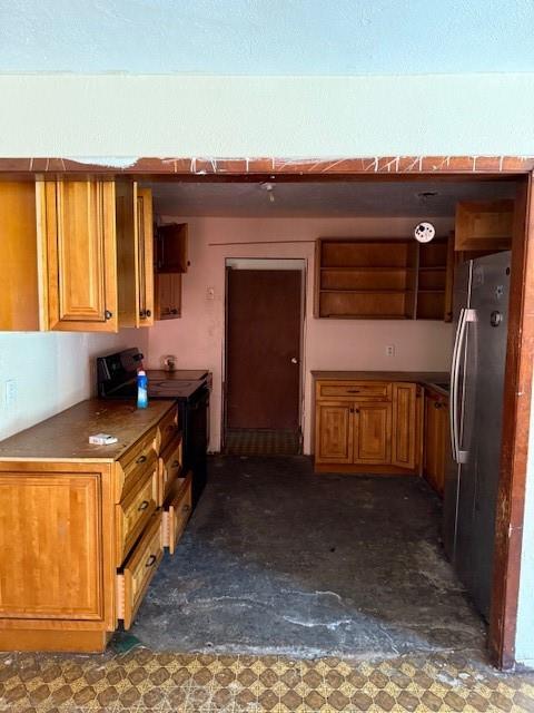 9800 North County Road Frisco, TX 75033 - Photo 7 of 14 Kitchen featuring brown cabinets, stove, refrigerator, and dark countertops