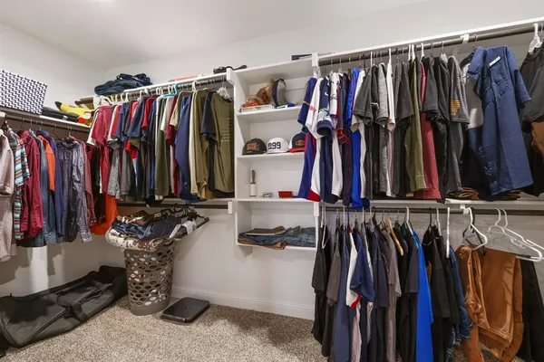a view of walk in closet with clothes