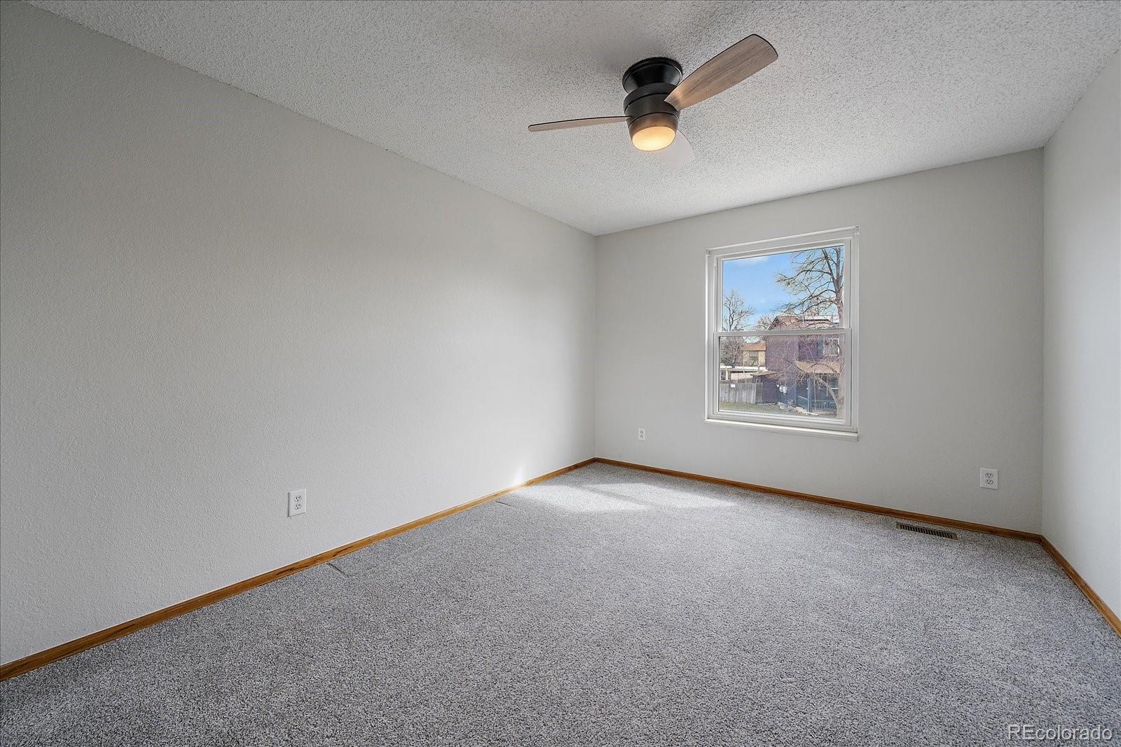 10961 Gray Circle Westminster, CO 80020 - Photo 18 of 24 an empty room with windows and ceiling fan