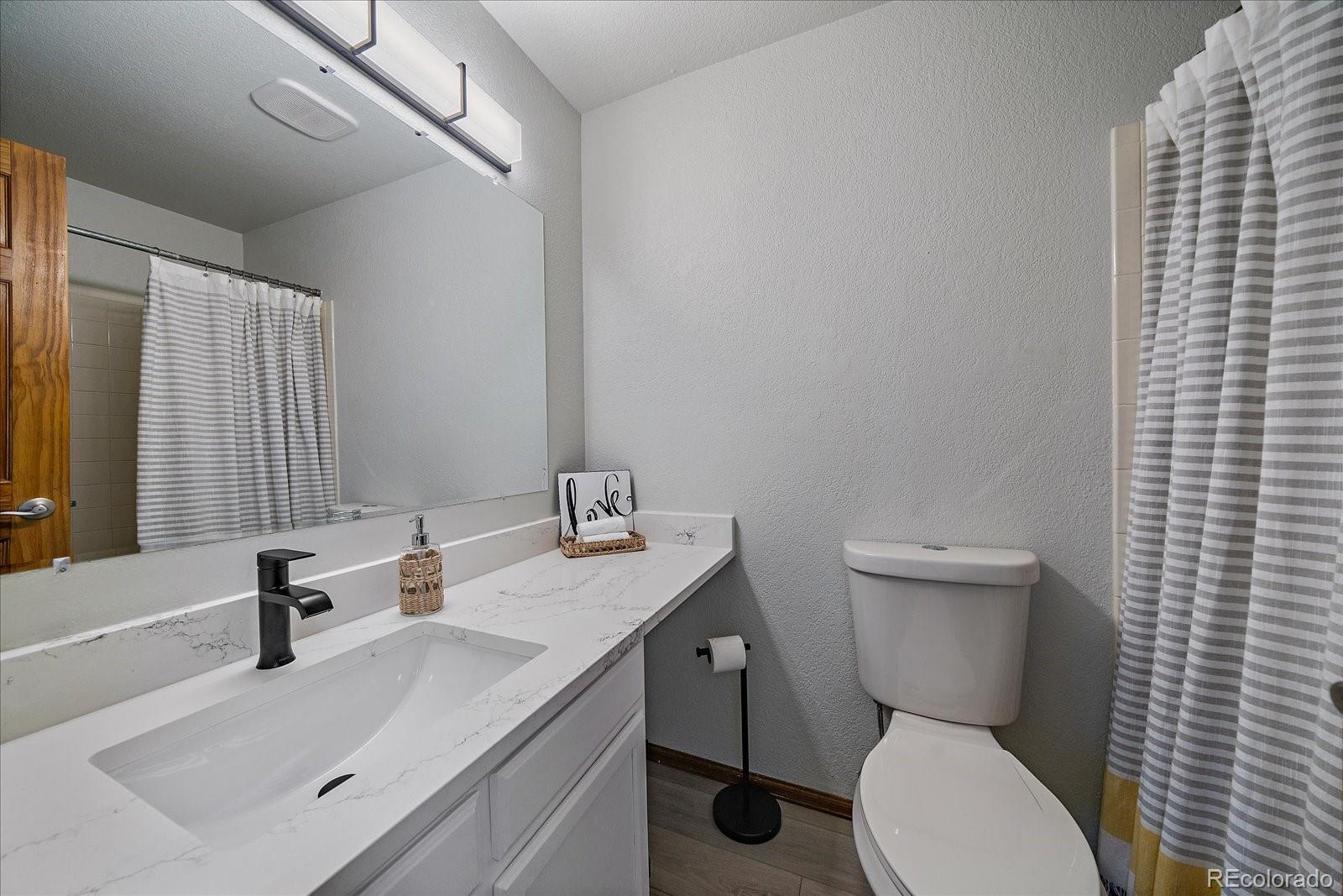 10961 Gray Circle Westminster, CO 80020 - Photo 20 of 24 a bathroom with a sink toilet vanity and tub