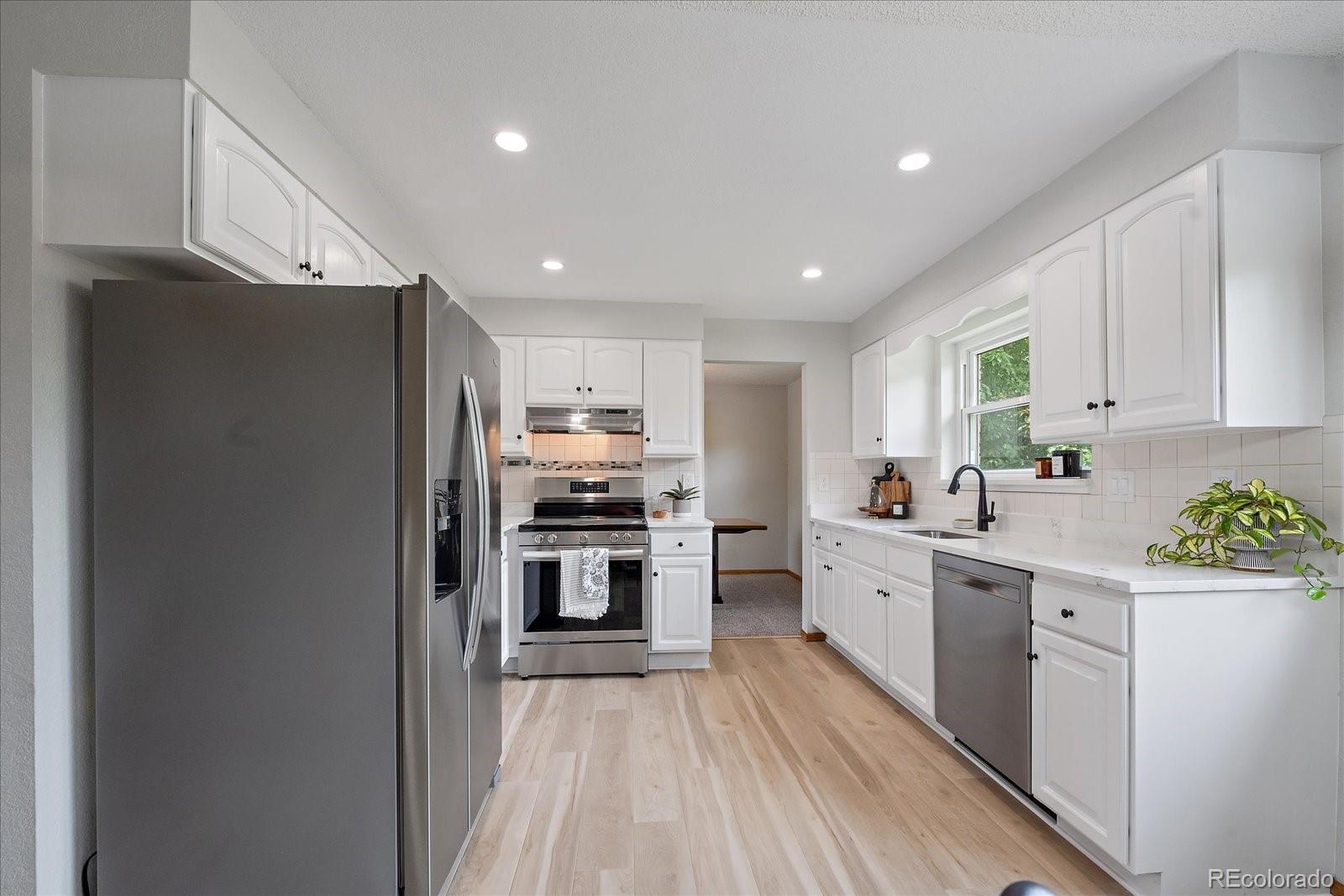 10961 Gray Circle Westminster, CO 80020 - Photo 7 of 24 a kitchen with stainless steel appliances a refrigerator stove and sink