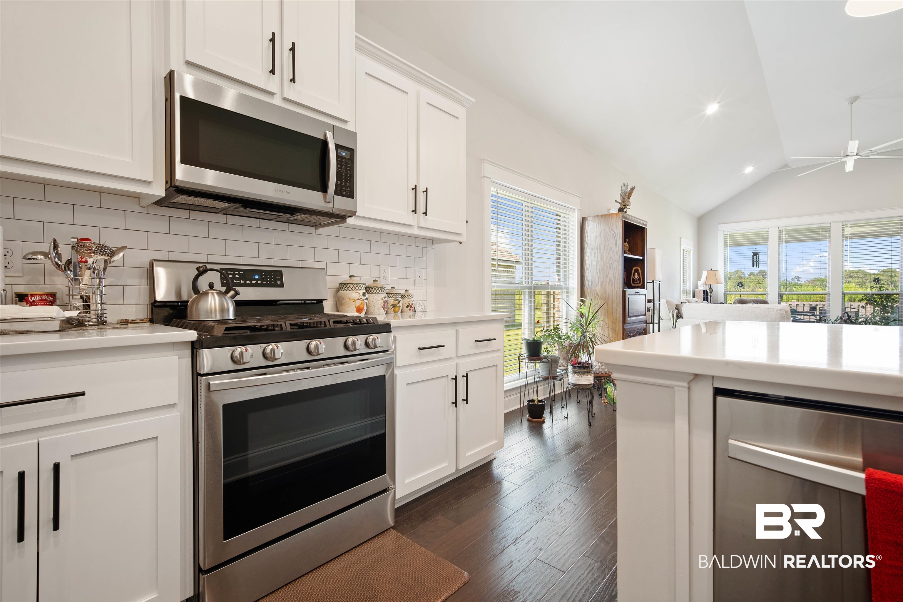 969 Charleston Loop Fairhope, AL 36532 - Photo 12 of 30 Kitchen featuring stainless steel appliances, dark wood-type flooring, decorative backsplash, and lofted ceiling