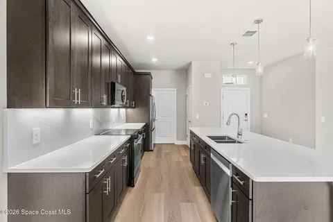 a kitchen with stainless steel appliances granite countertop a sink a stove and a refrigerator