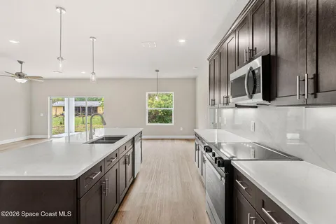 a kitchen with stainless steel appliances granite countertop a sink a stove and a refrigerator