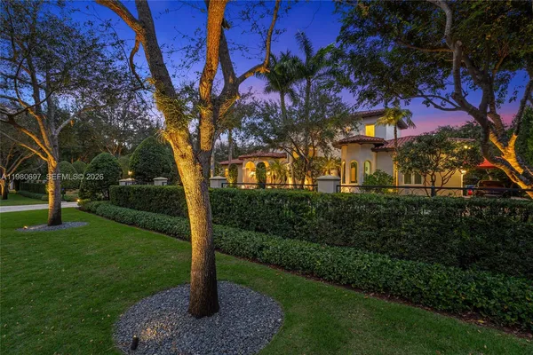 a front view of a house with a yard and tree s