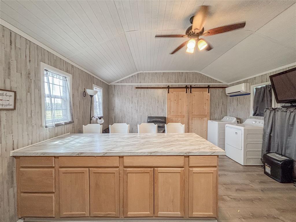 386 North Rock Creek Road Waco, TX 76708 - Photo 13 of 40 a kitchen with stainless steel appliances kitchen island granite countertop a refrigerator a sink dishwasher and white cabinets with wooden floor