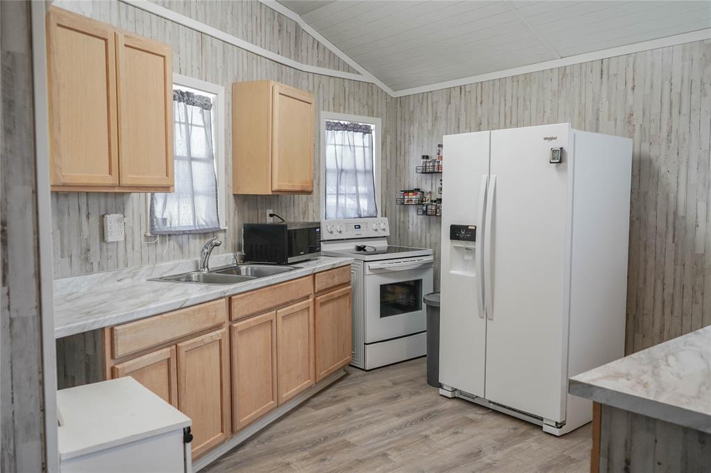 386 North Rock Creek Road Waco, TX 76708 - Photo 10 of 40 a kitchen with white cabinets and white appliances