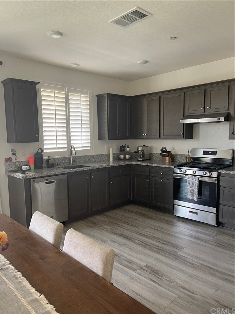 5895 Nectar Drive Banning, CA 92220 - Photo 4 of 29 a kitchen with stainless steel appliances granite countertop a sink counter space cabinets and a large window