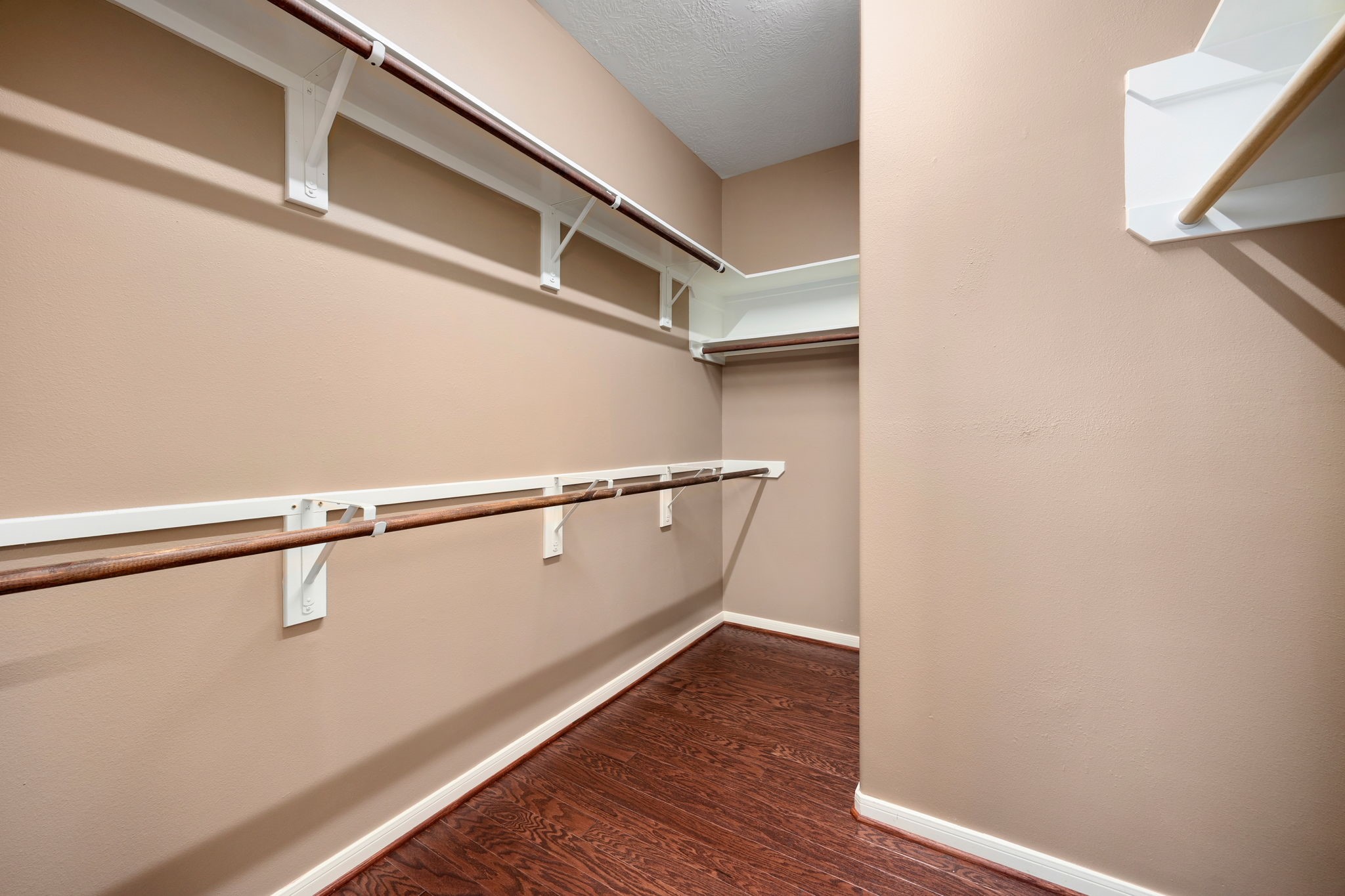 4526 Countrypines Drive Spring, TX 77388 - Photo 25 of 38 Massive primary walk-in closet offering an abundance of storage space with multi-level hanging rods and integrated storage shelving. The premium wood-look flooring extends seamlessly into this oversized wardrobe retreat.