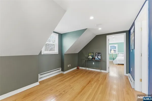 a view of hallway with wooden floor and cabinet