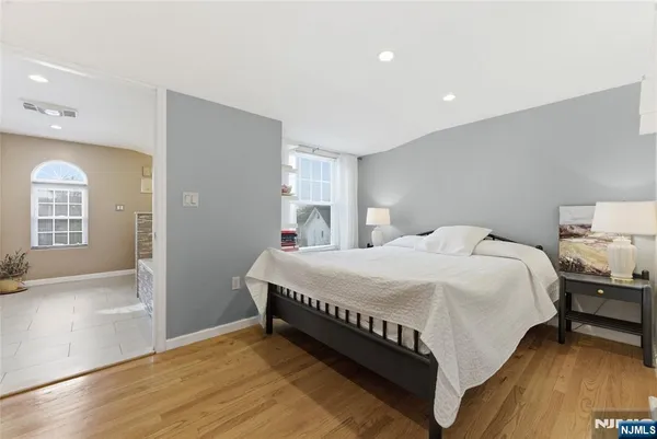a large bed sitting in a spacious bedroom next to a lamp