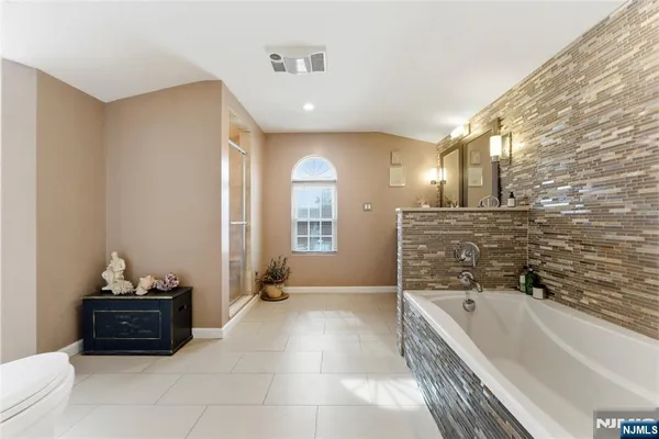 a spacious bathroom with a tub sink and mirror