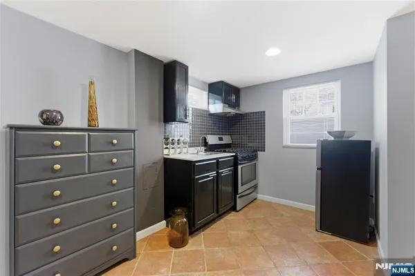 a kitchen with stainless steel appliances granite countertop a refrigerator and a stove top oven