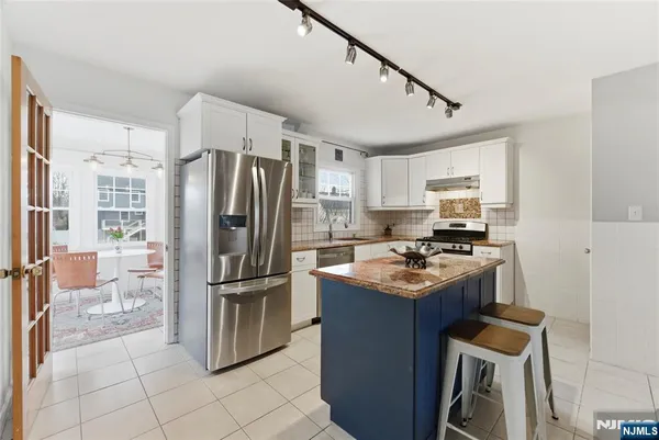 a kitchen with stainless steel appliances granite countertop a stove a refrigerator and a refrigerator