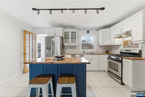 a kitchen with stainless steel appliances granite countertop a stove a sink dishwasher and a refrigerator