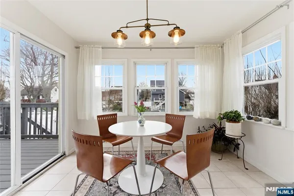 a dining room with furniture a chandelier and window