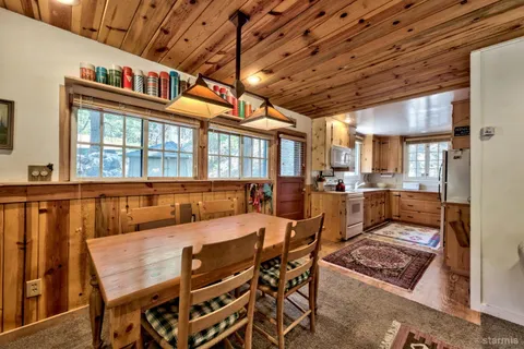a dining room with furniture and a floor to ceiling window